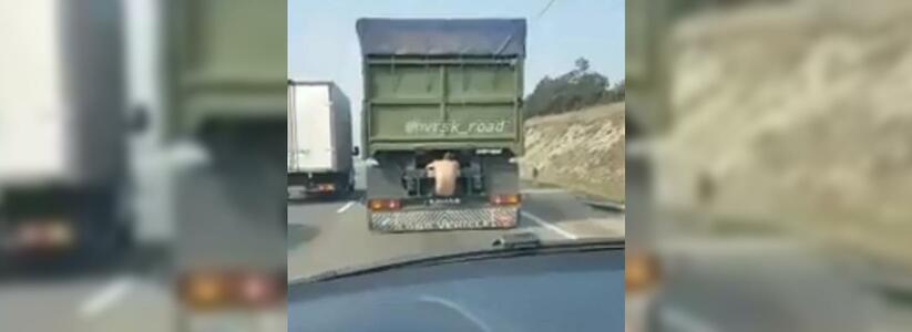 Автомобилисты Новороссийска сняли на видео, как полуголый мужчина катается по трассе, зацепившись за фуру