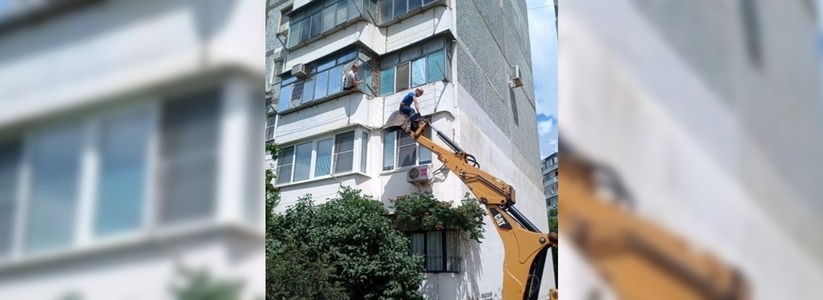 В Новороссийске спасатель поднялся на третий этаж на ковше экскаватора, чтобы помочь пенсионерке