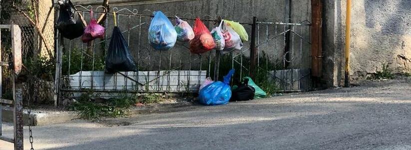 Жители улицы Сипягина в Новороссийске развешивают мешки с мусором прямо на заборе