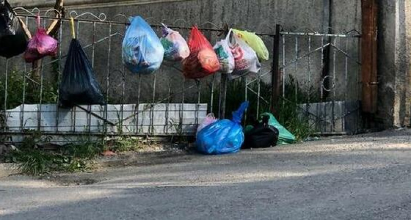 Жители улицы Сипягина в Новороссийске развешивают мешки с мусором прямо на заборе